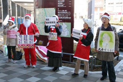 サンタ姿で歌を歌いながら宣伝する会のメンバー＝2013年12月16日、越谷市