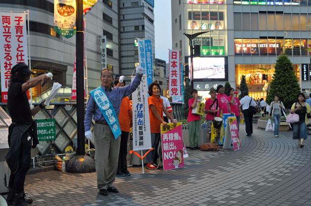 川口駅西口デッキ上で、「怒りのドラム隊」の村上ダミアン勝さんの応援も受け、市民に訴える伊藤岳候補=18日