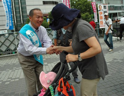 子ども連れのお母さんと握手する伊藤候補=19日、川口駅東口デッキ上