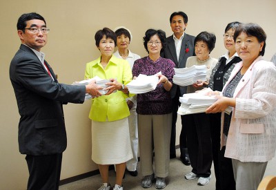 県の担当者に署名を渡す参加者ら＝2013年10月8日、埼玉県庁内