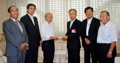 土橋義男副市長（右から3人目）に募金を渡す黒崎本部長（左から3人目）、村岡県議（同2人目）ら＝2013年10月10日、行田市