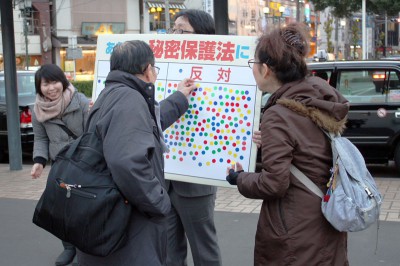 反対のシールを貼る市民＝2013年12月5日、さいたま市