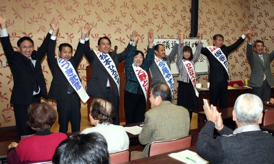 市議選勝利に決意を込める（左2人目から）うづき、松本、大野、今尾、わたなべ、坂巻の6氏と塩川衆院議員（左端）＝2013年12月14日、春日部市