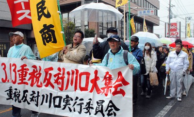 雨の中「消費税増税反対」と訴えて歩く人たち＝2014年3月13日、川口市