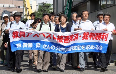提訴の前にデモ行進する四條さん（中央）と弁護団、支援者＝2014年7月30日、さいたま市