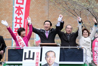 聴衆の声援にこたえる（左から）新藤たか子県議候補、山下芳生書記局長、伊藤岳参院埼玉選挙区候補、奥田智子参院比例候補＝2015年4月5日、上尾市