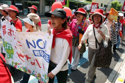 赤い衣服を身につけ「戦争する国ノー」と訴えた女性たち＝2015年4月28日、さいたま市