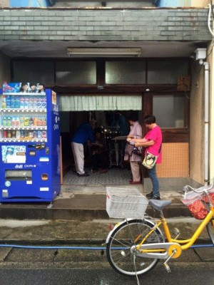 銭湯前で署名に取り組む市民＝越谷市