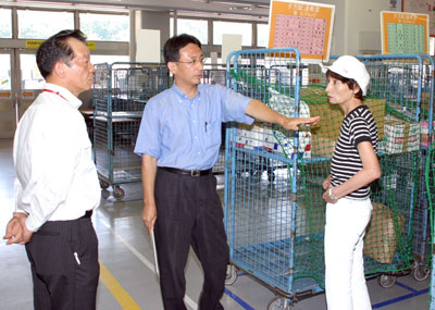 作業現場で説明を受ける塩川前衆院議員(中央)と柳下県議(右)=7月30日、所沢市